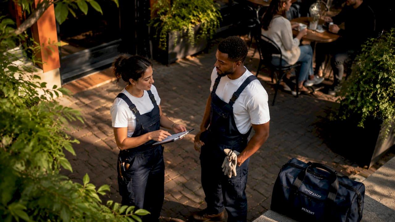 Plumbers discussing referral hiring outdoors