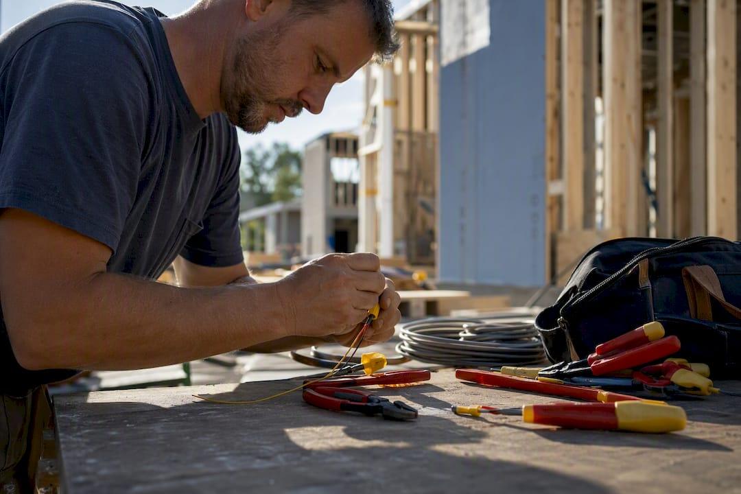 Electrician arranging hand tools on workbench